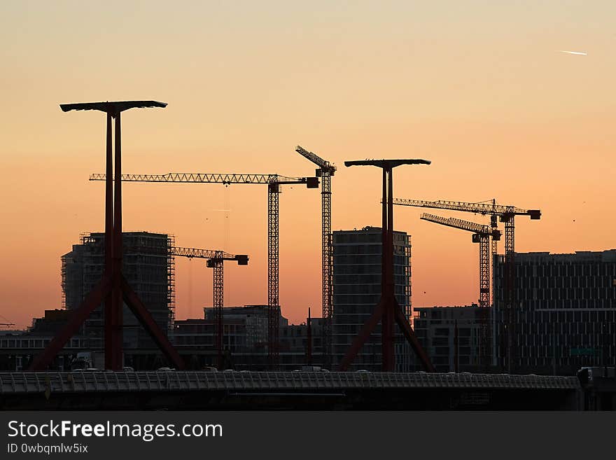 Construction cranes against twilight sky, huge buildings. Construction cranes against twilight sky, huge buildings