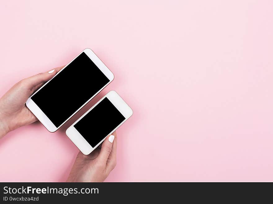 Two cellphones in different sizes in woman hands. Small or big phone concept. Screens are mockups so it`s easy to show responsive design on different devises