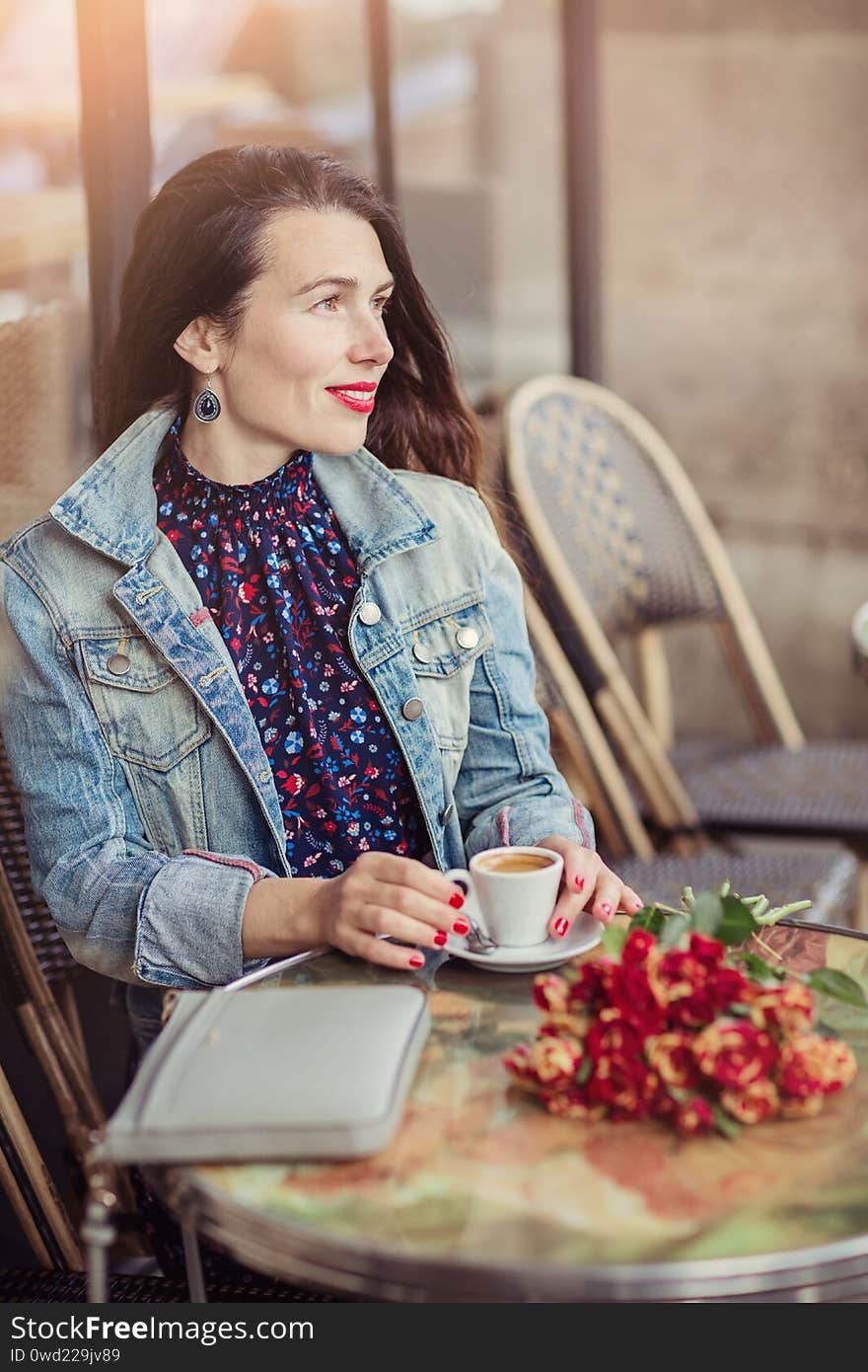 Happy pensive woman thinking in a coffee shop terrace in the street. Relaxing and thinking while drinking coffee.