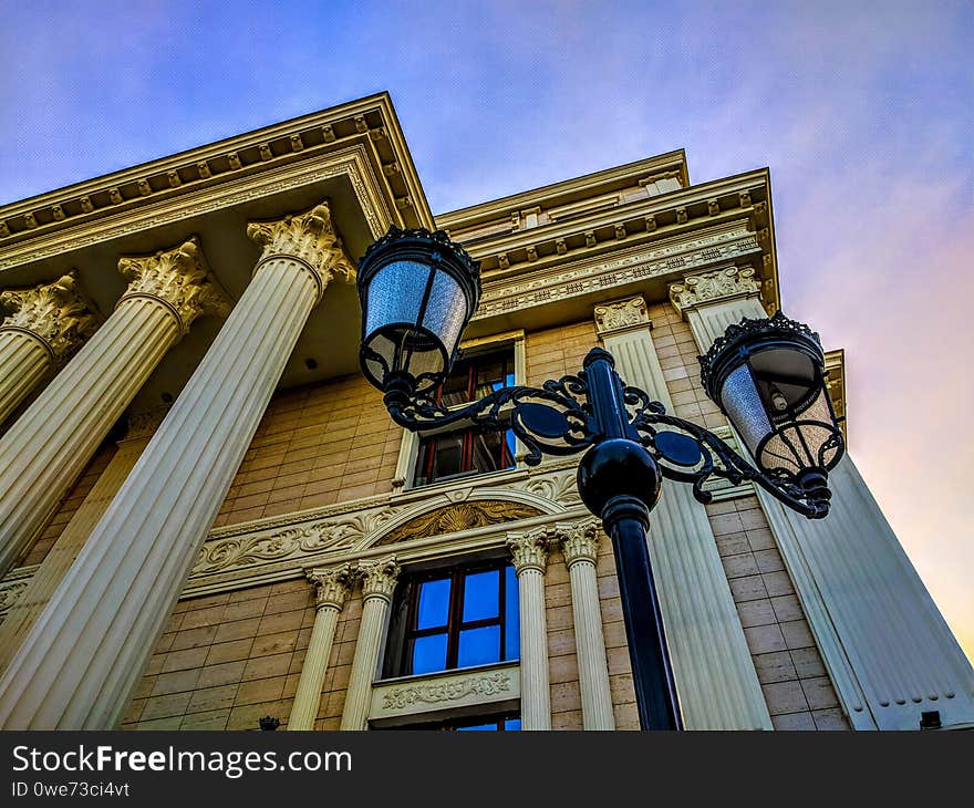 Upper view to a street lamp and a corner of a building. Upper view to a street lamp and a corner of a building.