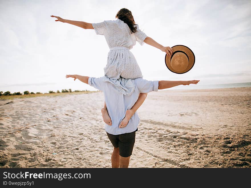 Honeymoon on a desert island. Happy young couple walking on the beach. The concept of freedom.