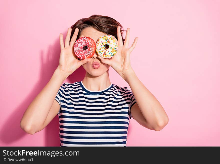 Closeup photo of attractive funny lady hold hands two sweet baked, donuts like specs near eyes sending air kisses wear casual white blue t-shirt isolated pastel pink color background. Closeup photo of attractive funny lady hold hands two sweet baked, donuts like specs near eyes sending air kisses wear casual white blue t-shirt isolated pastel pink color background