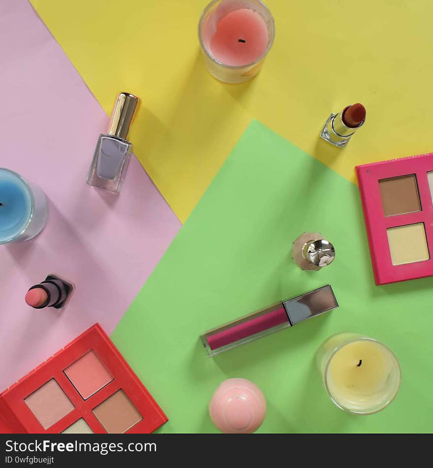 Flat lay of cosmetics and make up products on a colorful background.