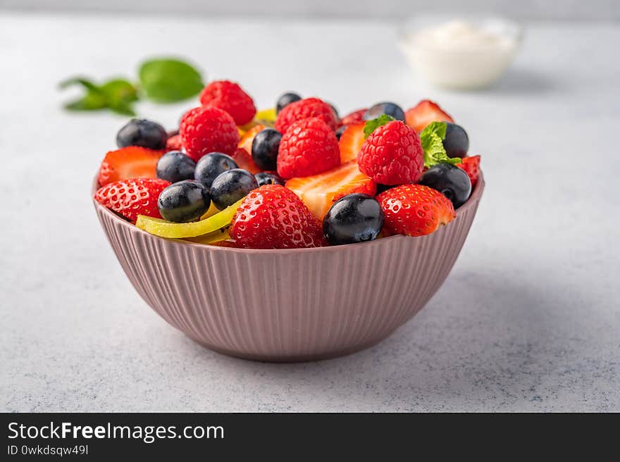 Fresh fruit salad with different ingredients with mint and sour cream. Healthy diet. Copy space for text. Close up