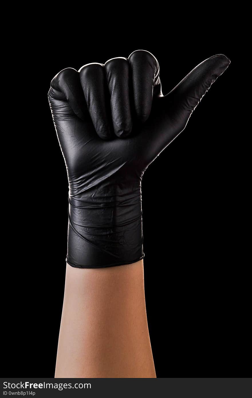 Hand in black gloves showing gesture of like sign, giving thumb up on black background. Isolated with clipping path