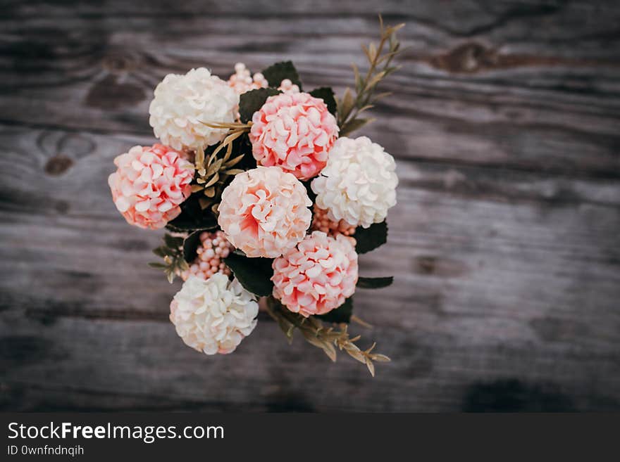 Fake flowers in a vase on the table background.