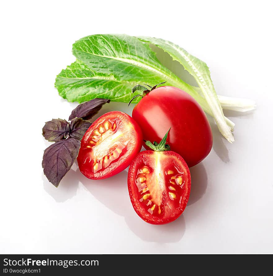 cherry tomatoes with fresh young red Basil leaves and Romaine lettuce leaves isolated on a white background