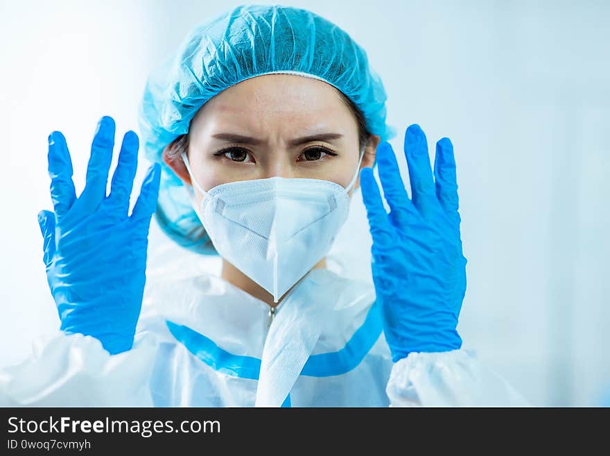 Asian woman doctor look to you and show medical gloves on her hands with facial mask in hospital. Asian woman doctor look to you and show medical gloves on her hands with facial mask in hospital