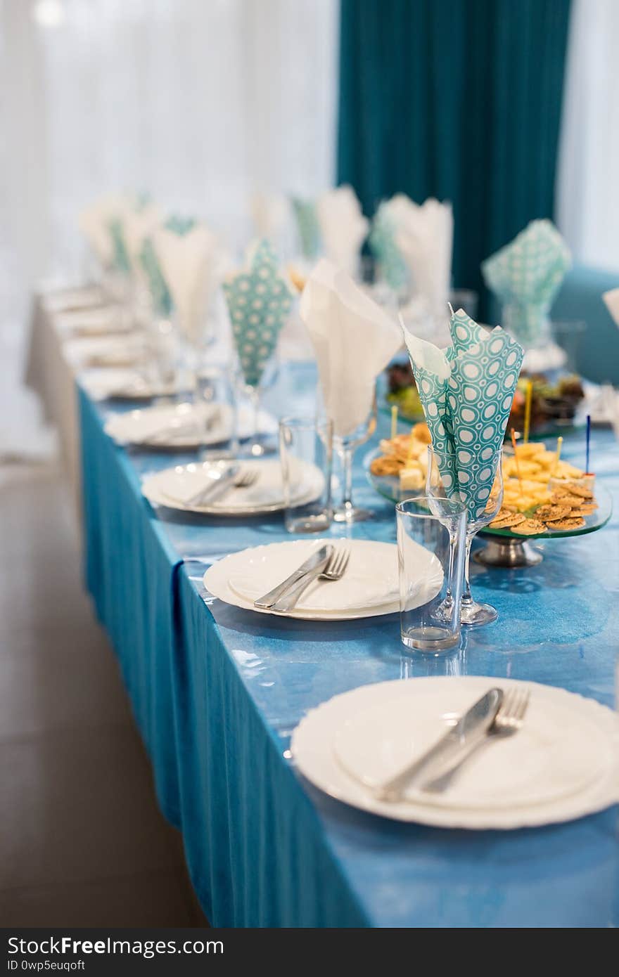 Birthday served blue table before selebration. Preparation banguet table with blue white napkins in the restaurant. Festive setting table