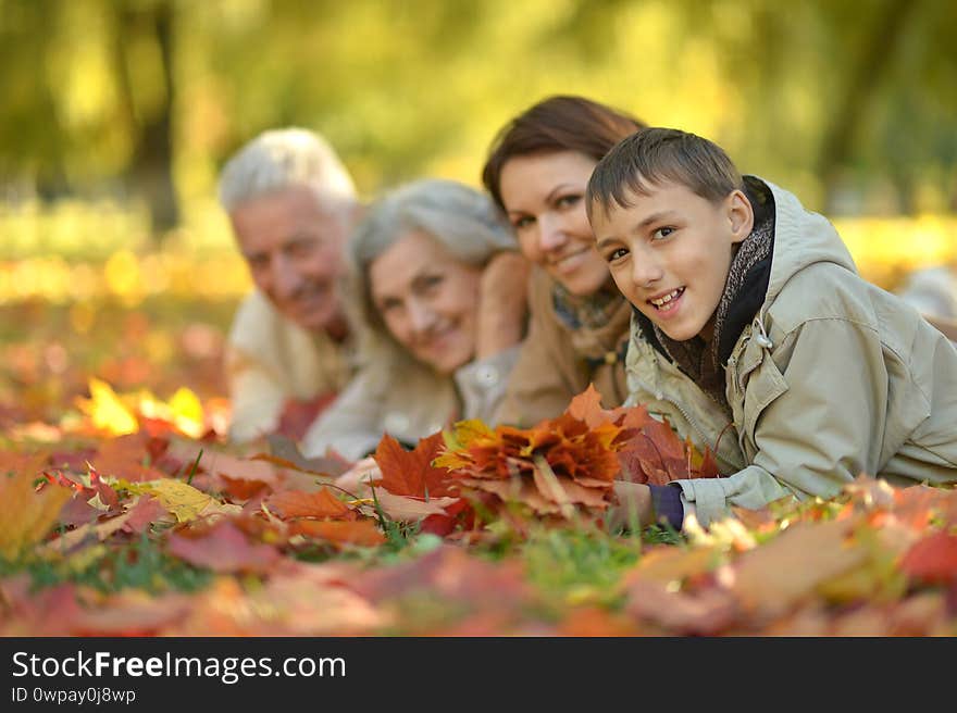 Portrait of happy family relaxing in autumn forest