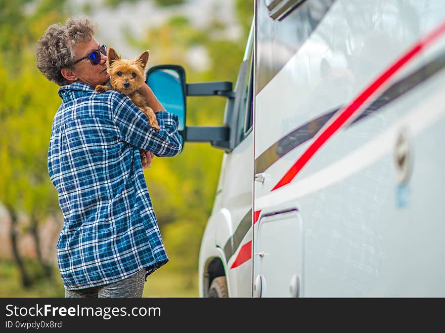 Retired Woman on the Road Trip with Her Small Breed Australian Silky Terrier Dog. Class C Motorhome. Summer Vacation. Retired Woman on the Road Trip with Her Small Breed Australian Silky Terrier Dog. Class C Motorhome. Summer Vacation
