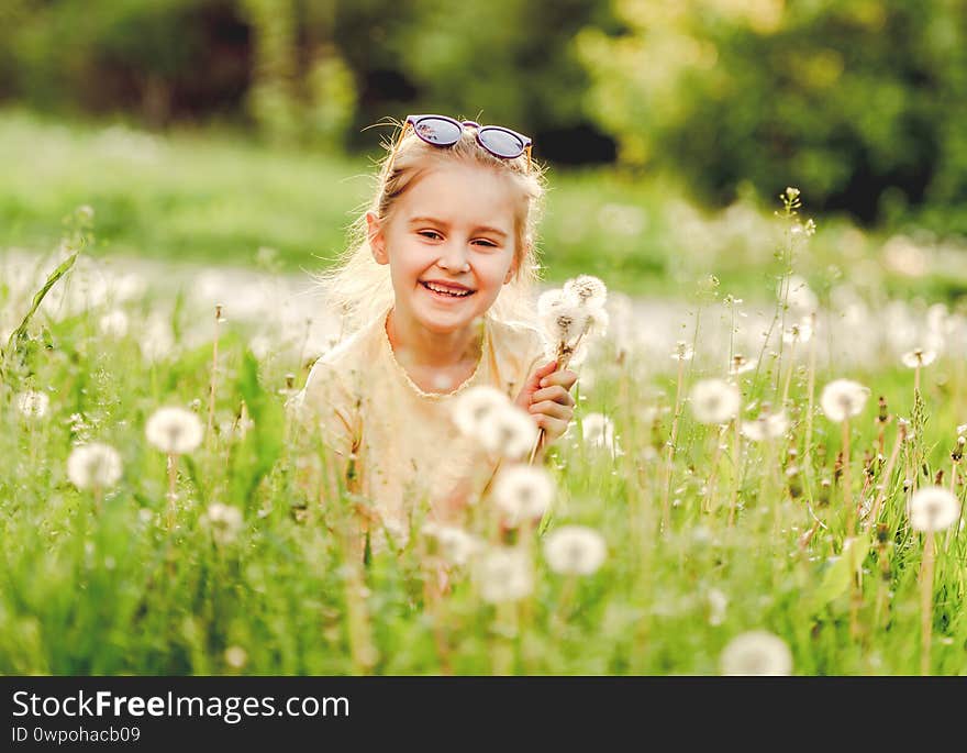 Little girl outside on dandelion field