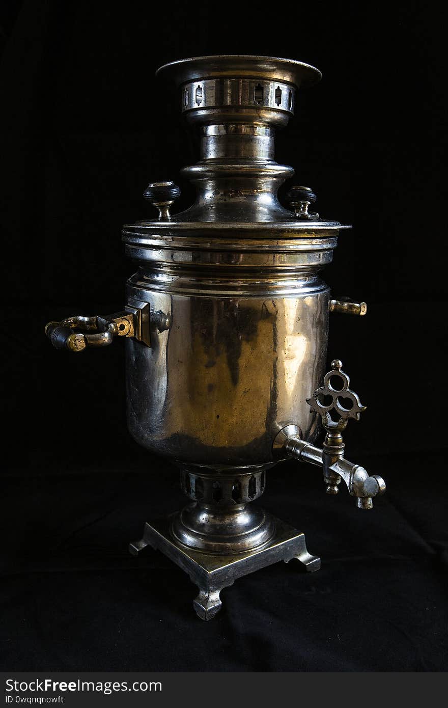 An old samovar isolated on a black background. Metal vessel for boiling water and making tea.Russian samovar