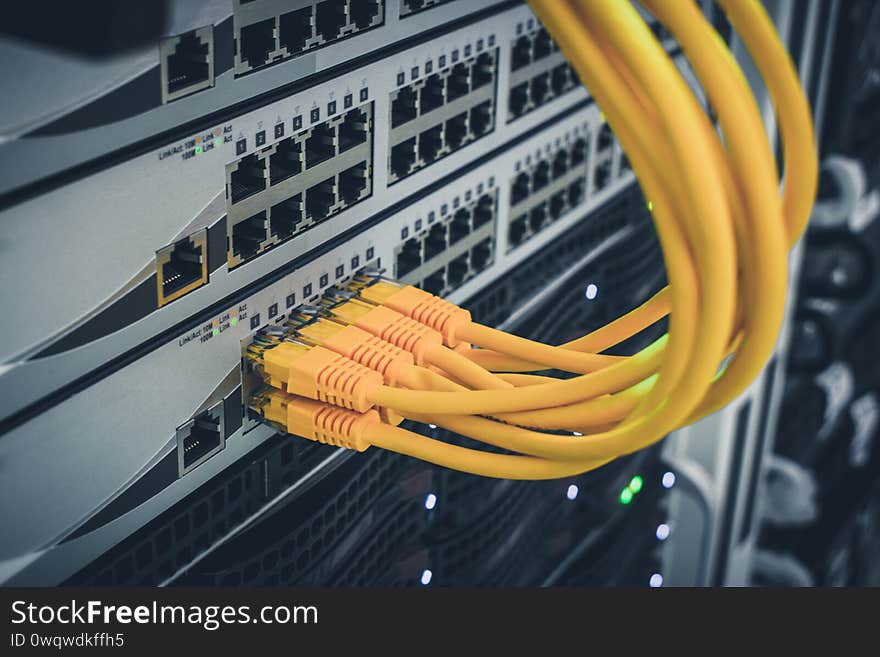 The technological concept of a modern data center. A bunch of yellow utp cables connect to the network interfaces of the Internet.