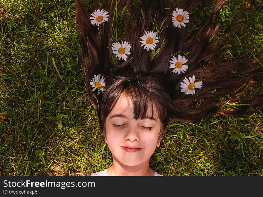 Girl with daisies in hands on the field. Selective focus