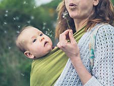 Mother With Baby Blowing Dandelion Royalty Free Stock Photos