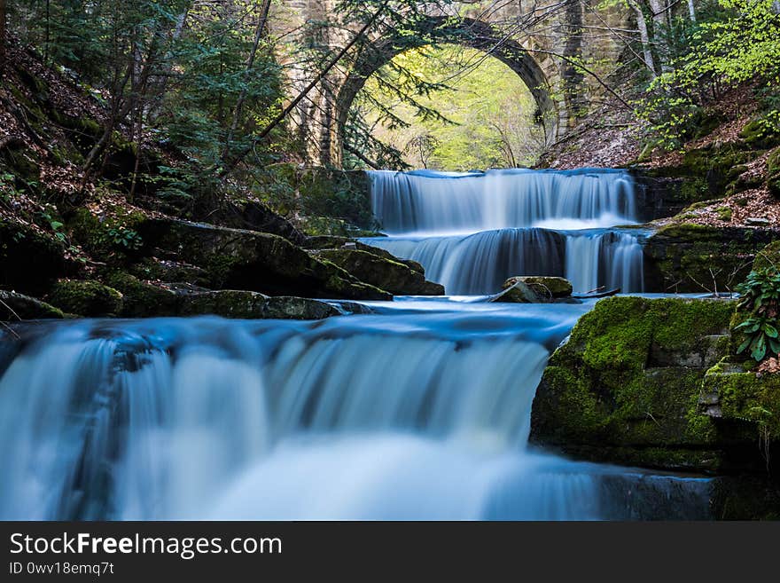 Long exposure waterfall in a mount with a bridge above. Summer trips to remote location during the pandemic. Long exposure waterfall in a mount with a bridge above. Summer trips to remote location during the pandemic.