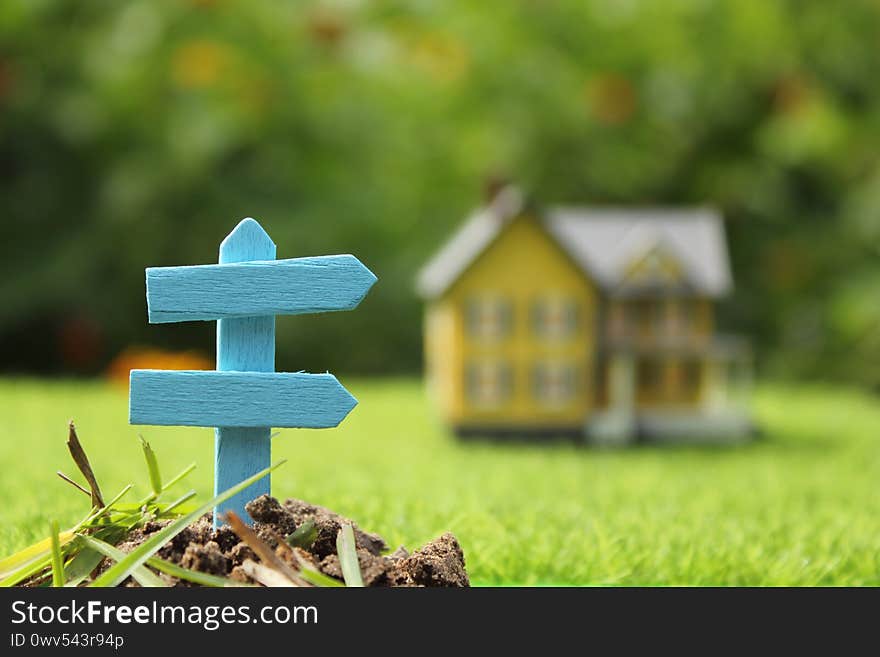 Rustic Signboard in Rural  Outdoor Area, Blurred Farmhouse in background. Rustic Signboard in Rural  Outdoor Area, Blurred Farmhouse in background