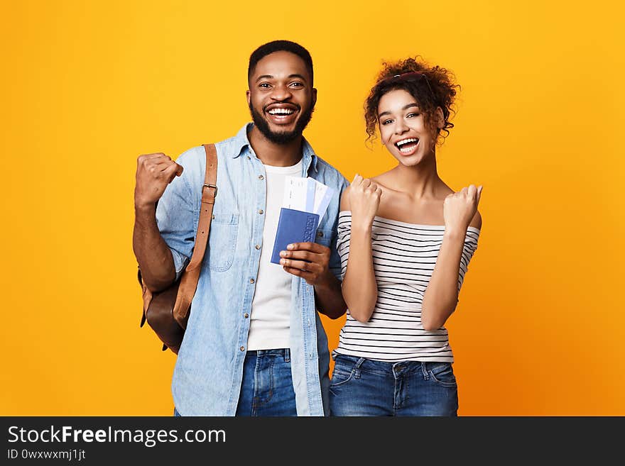 Travel Together. Happy African Couple Holding Flight Tickets Gesturing Yes Posing Over Yellow Studio Background. Travel Together. Happy African Couple Holding Flight Tickets Gesturing Yes Posing Over Yellow Studio Background.