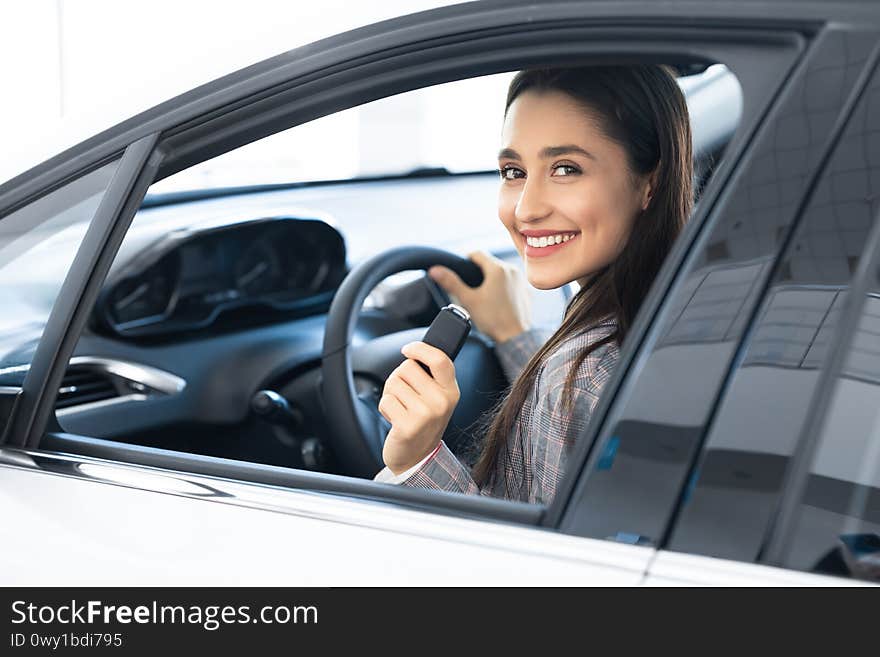 Confident And Beautiful. Girl Showing Car Keys To Camera Sitting In Driver`s Seat In Her Brand-New Auto. Confident And Beautiful. Girl Showing Car Keys To Camera Sitting In Driver`s Seat In Her Brand-New Auto