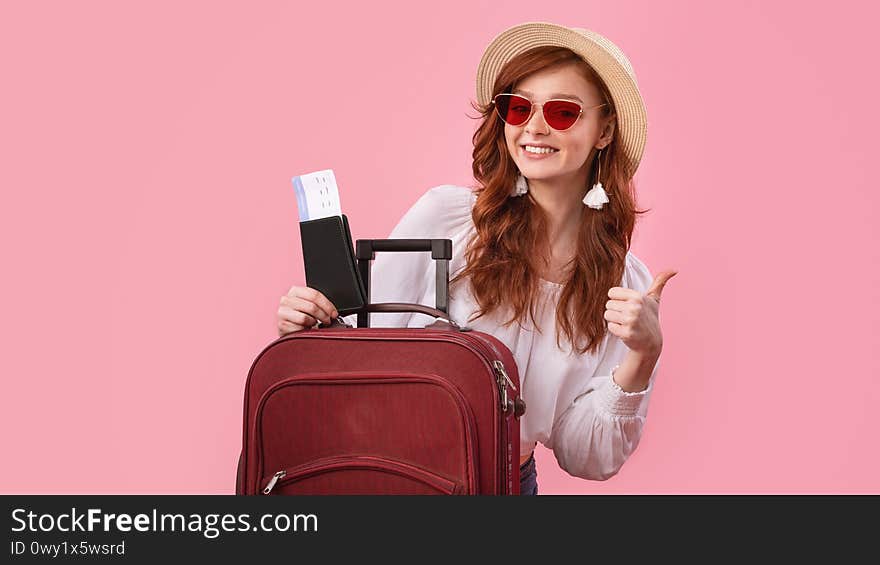 I Like Travel. Girl Posing With Suitcase Holding Tickets And Passport Gesturing Thumbs Up Over Pink Studio Background. Panorama. I Like Travel. Girl Posing With Suitcase Holding Tickets And Passport Gesturing Thumbs Up Over Pink Studio Background. Panorama