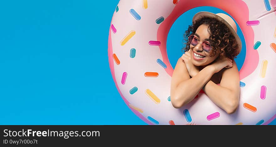 Dreaming About Vacation. Pensive black woman looking out of inflatable donut