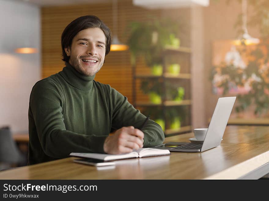 Businessman starting day at cafe, planning his day