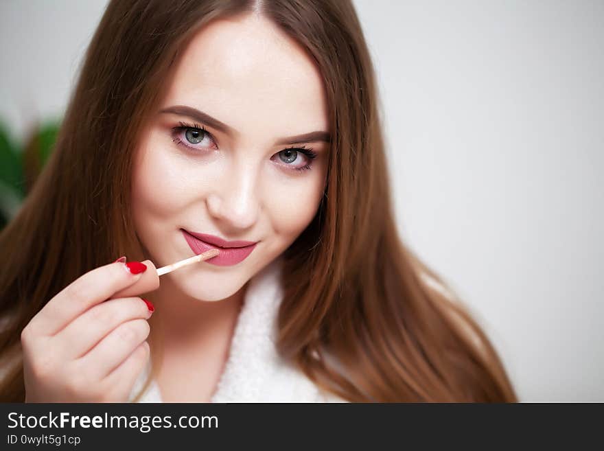 Beautiful girl with healthy skin makes makeup.
