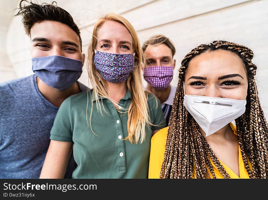 Group of young people taking selfie with phone camera while wearing protective masks - Happy friends taking photos during coronavirus outbreak - Social distancing concept