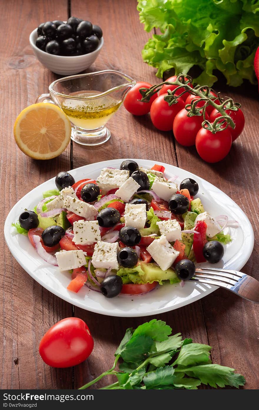 Greek salad with fresh cucumber , tomatoes, sweet pepper, lettuce, red onion, feta cheese and olives with olive oil. Healthy diet