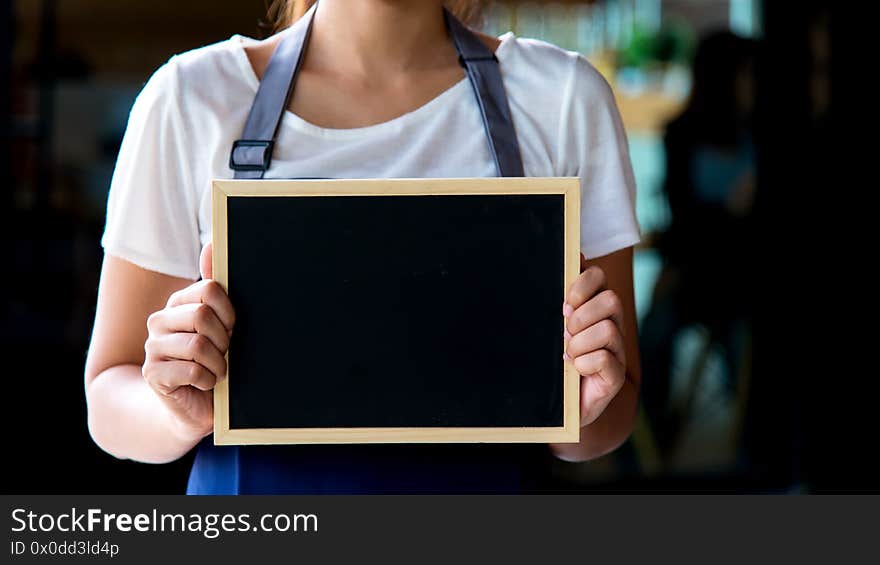 Barista asian women holding label Coffee order in the coffee shop. Service Concept