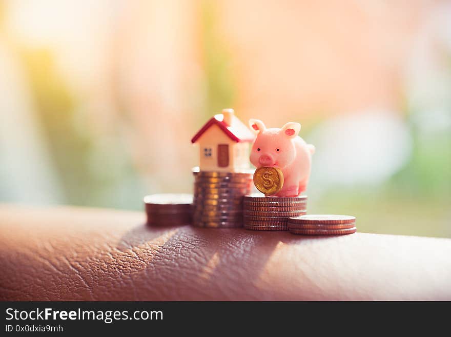 Closeup Piggy Bank On Stack Coins With Mini House