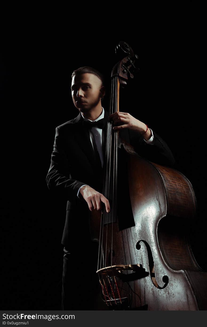 Professional musician playing on contrabass isolated on black