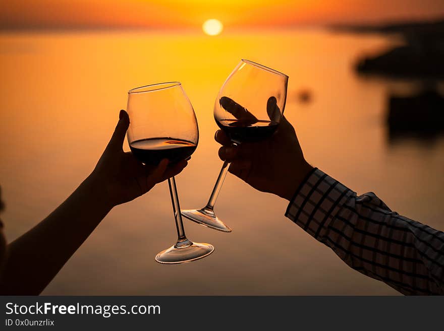 Man And Woman Clanging Wine Glasses With Champagne At Sunset Dramatic Sky Background