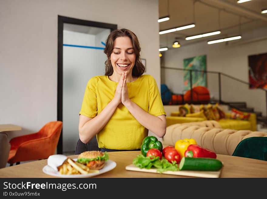 Smiling young woman at the table with food.