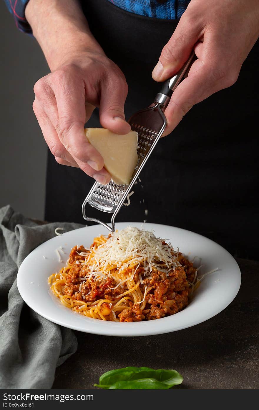 Man serving spaghetti with cheese, italian food serving