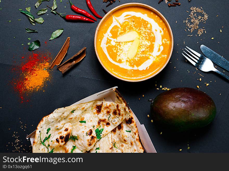 Indian food on a dark background, in paper utensils, photos for menus and advertising. Additives and spicy spices. Indian food on a dark background, in paper utensils, photos for menus and advertising. Additives and spicy spices.