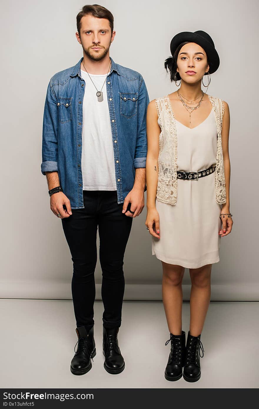 Full length view of stylish couple standing straight and looking at camera