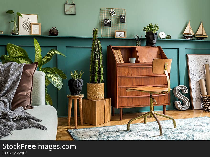 Stylish and vintage interior design of open space with retro furniture, plants and decoration.