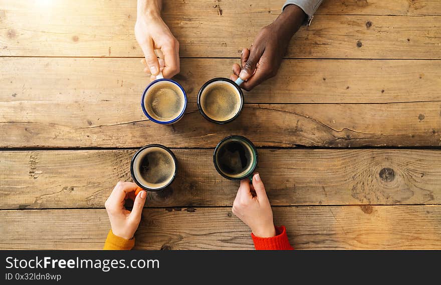 Friends group drinking coffee in a bar restaurant - People hands cheering and toasting on top view point - Social gathering