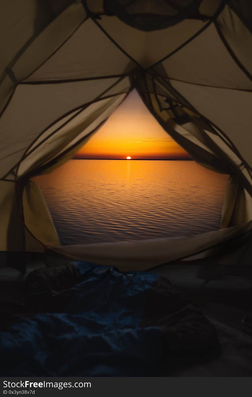 The tent has a sleeping bag by the sea. .From the tent, view of the sunrise and the sea. The tent has a sleeping bag by the sea. .From the tent, view of the sunrise and the sea