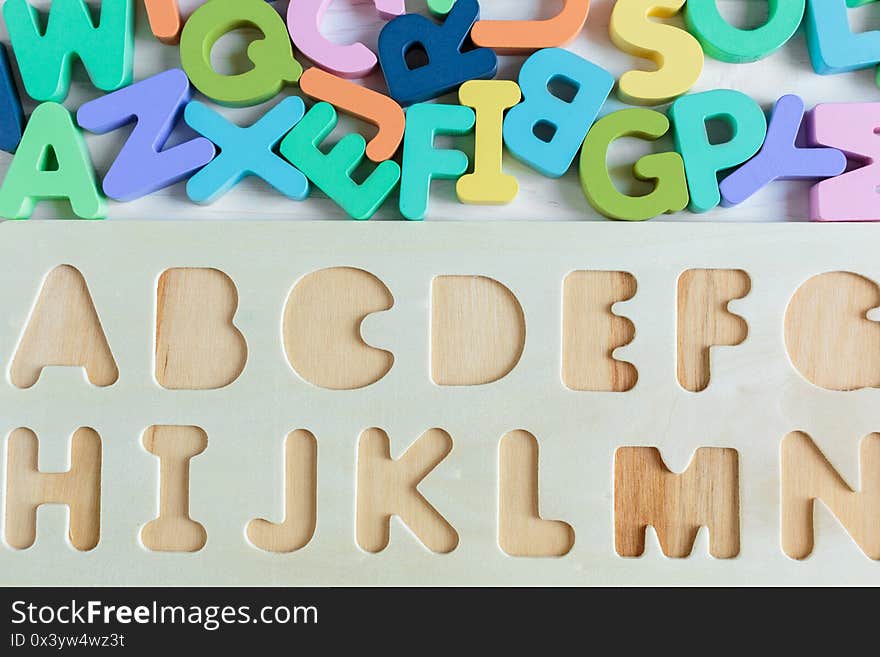 Close up Multicolored wooden numbers on white wooden background. Set of toys for studying mathematics. Education, back to school