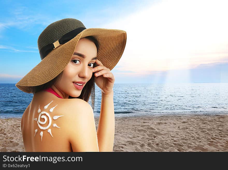 Woman with sun protection cream on her back at beach, space for text