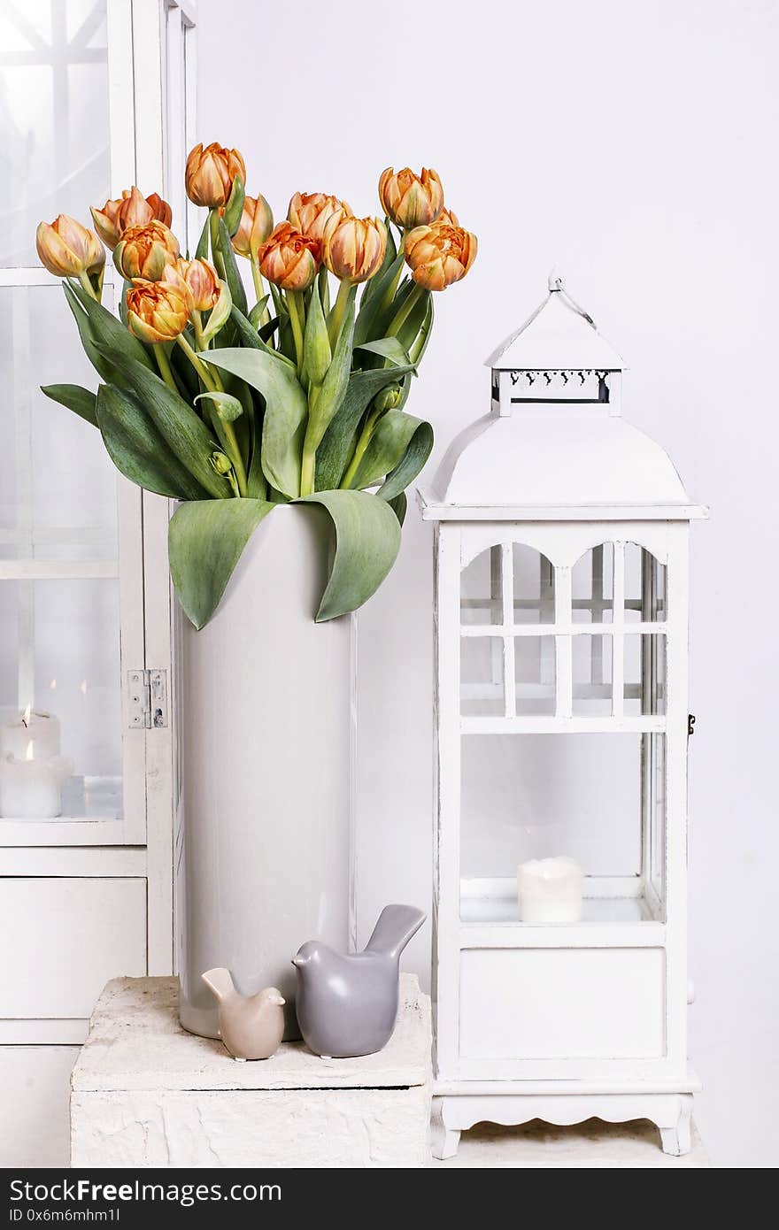 Bouquet of pink tulips and wooden lanterns in the background. Party decor