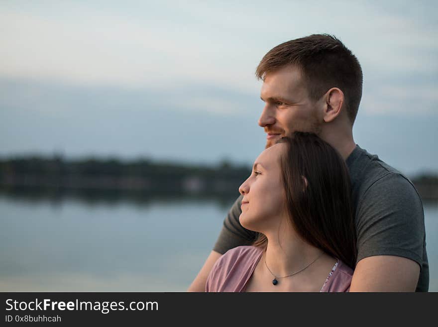 Young couple hugging at the beach, emotional.