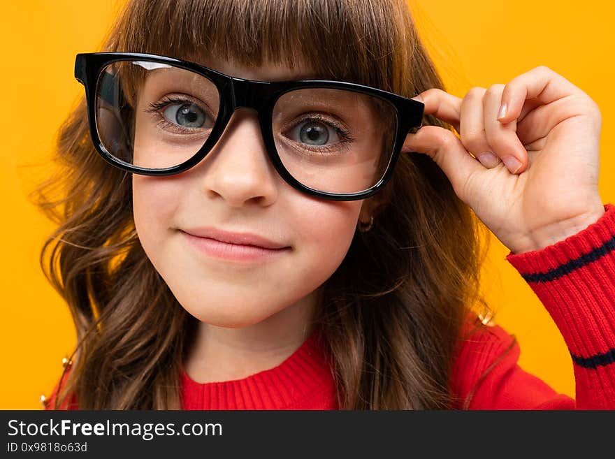 Beautiful little girl in dress isolated on yellow or orange background