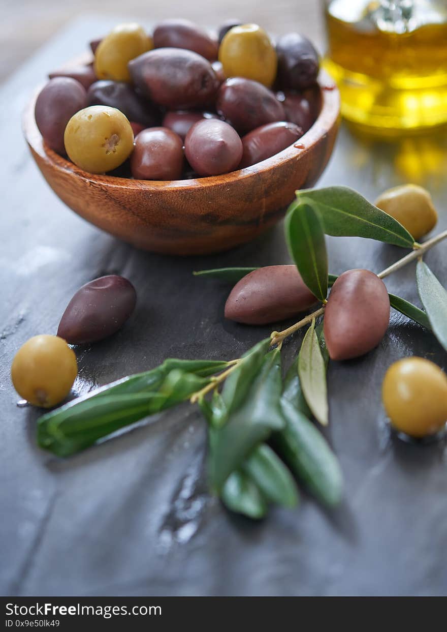 Marinated olives in a bowl on slate board. Selective focus on olive fruits. Marinated olives in a bowl on slate board. Selective focus on olive fruits