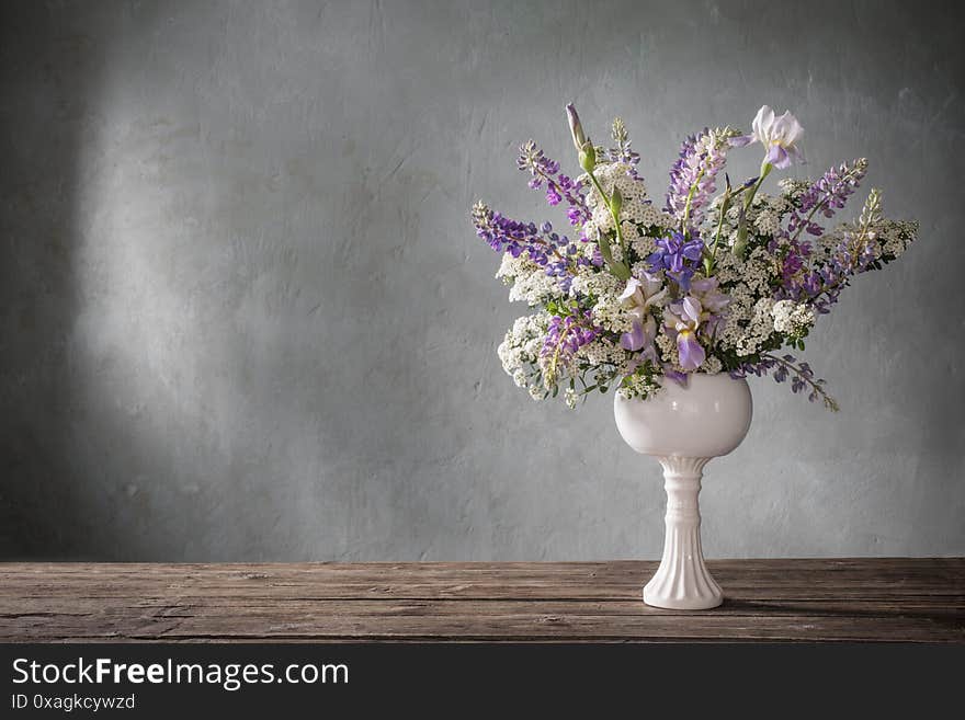 Summer bouquet in white vase  on gray background. Summer bouquet in white vase  on gray background