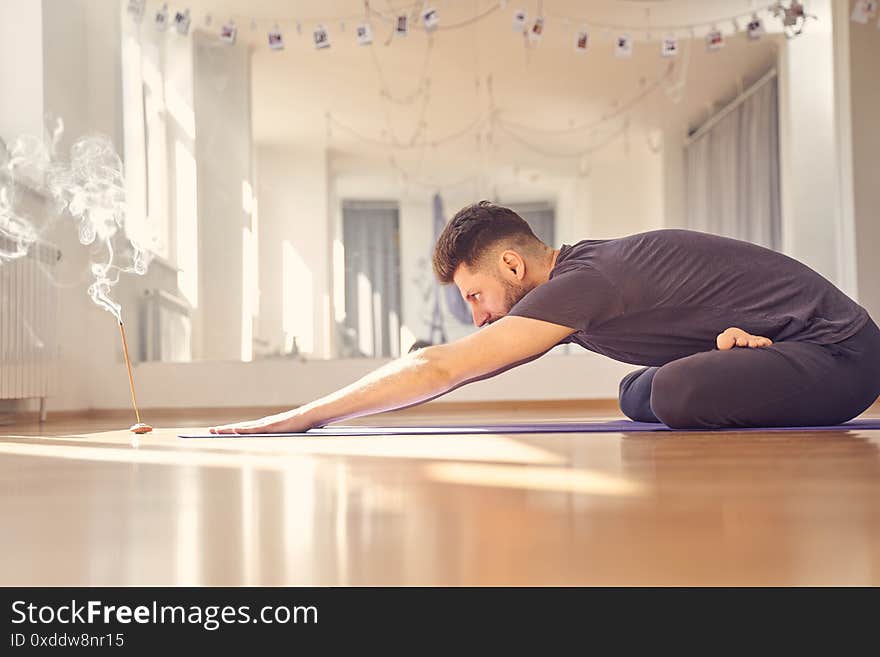 Bearded Young Man Doing Exercise In Yoga Studio