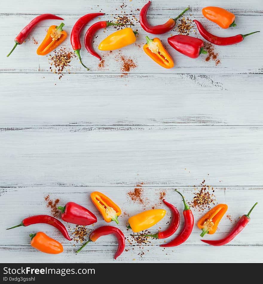 Raw fresh organic red chili pepper and assorted spices on light wooden background. Seasonings for food frame